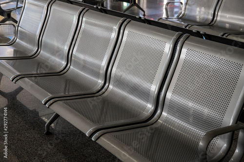 Fototapeta Naklejka Na Ścianę i Meble -  Metallic chair row for airport customers. Modern public place asset. Waiting in airport concept. Metallic furniture