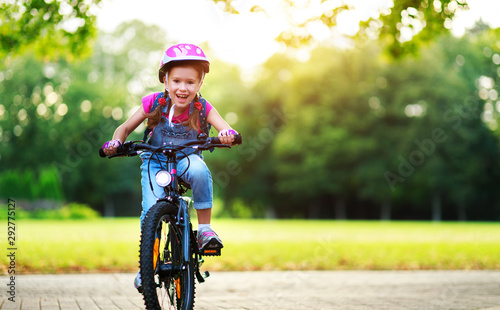 happy cheerful child girl riding a bike in Park in nature. photo