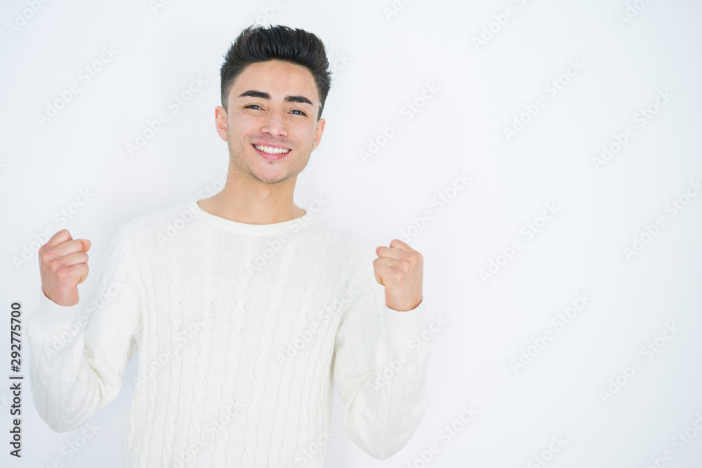 Handsome young man over white isolated background celebrating surprised and amazed for success with arms raised and open eyes. Winner concept. Handsome young man over white isolated background celebrating surprised and amazed for success with arms raised and open eyes. Winner concept.