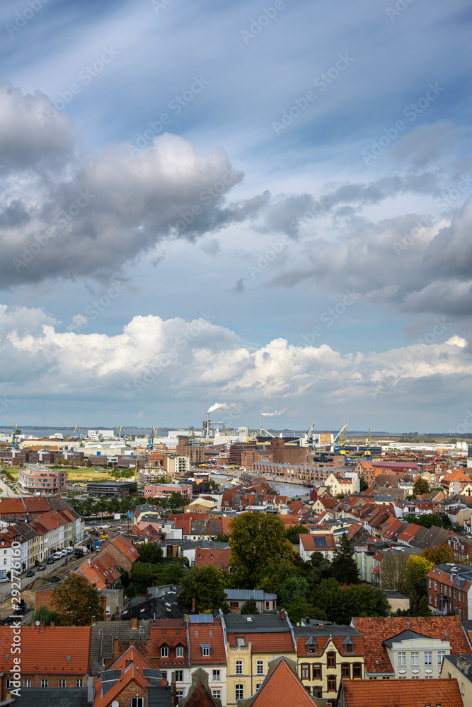 wismar cityscape from above with old town and port industry at the baltic sea, aerial high angle view, seen from the top of the st. georgen church, blue sky with clouds, copy space