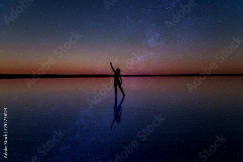 Silhoutte of girl dancing under milky way at Lake Tyrrell