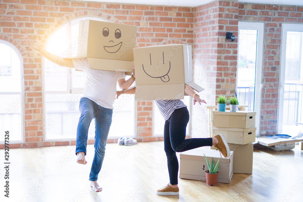 Couple wearing funny cardboard boxes with happy faces, moving to a new house, crazy and creative concept - obrazy, fototapety, plakaty 