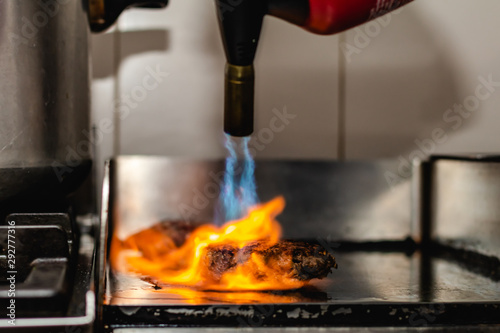 Foto Some patties of ground meat with a flame with the blowtorch