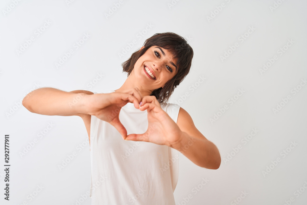 Young beautiful woman wearing casual t-shirt standing over isolated white background smiling in love showing heart symbol and shape with hands. Romantic concept. Young beautiful woman wearing casual t-shirt standing over isolated white background smiling in love showing heart symbol and shape with hands. Romantic concept.