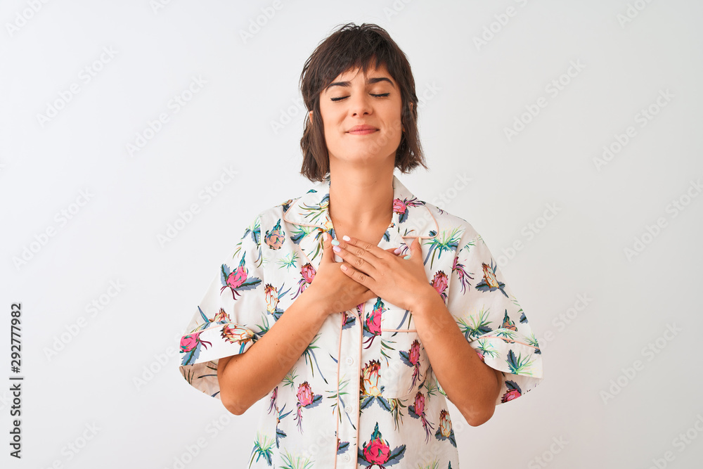 Beautiful woman on vacation wearing summer casual shirt over isolated white background smiling with hands on chest with closed eyes and grateful gesture on face. Health concept. Beautiful woman on vacation wearing summer casual shirt over isolated white background smiling with hands on chest with closed eyes and grateful gesture on face. Health concept.