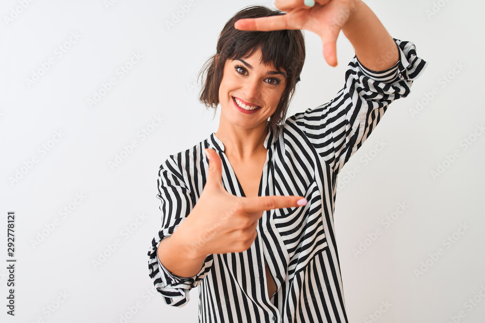 Young beautiful woman wearing striped shirt standing over isolated white background smiling making frame with hands and fingers with happy face. Creativity and photography concept.