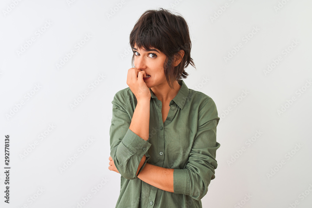 Young beautiful woman wearing green casual shirt standing over isolated white background looking stressed and nervous with hands on mouth biting nails. Anxiety problem. Young beautiful woman wearing green casual shirt standing over isolated white background looking stressed and nervous with hands on mouth biting nails. Anxiety problem.