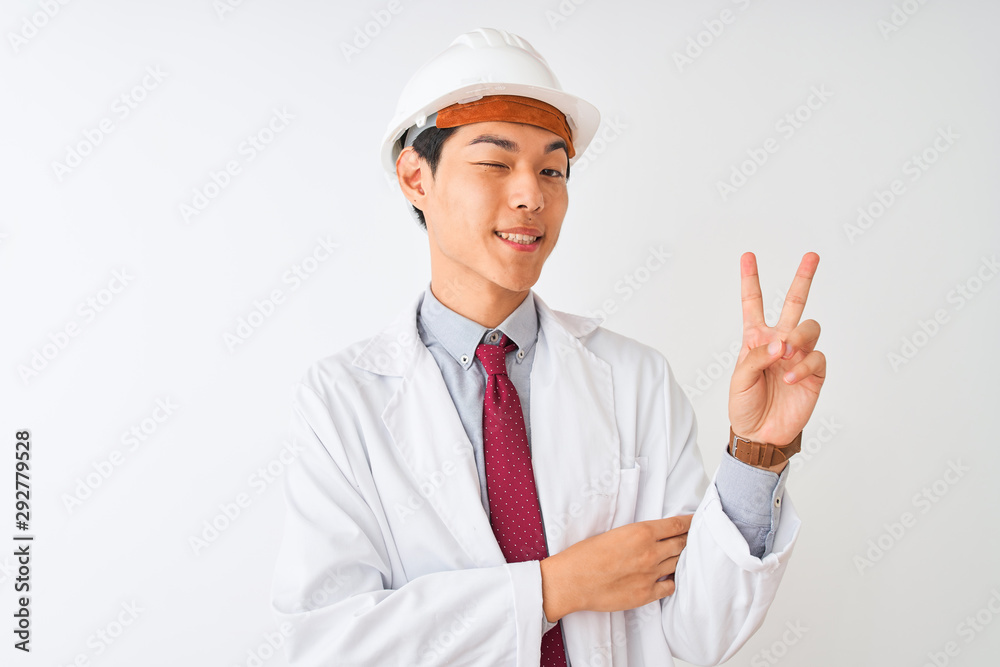 Chinese architect man wearing coat and helmet standing over isolated white background smiling with happy face winking at the camera doing victory sign. Number two. Chinese architect man wearing coat and helmet standing over isolated white background smiling with happy face winking at the camera doing victory sign. Number two.