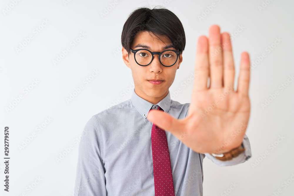 Chinese businessman wearing tie and glasses standing over isolated white background with open hand doing stop sign with serious and confident expression, defense gesture Chinese businessman wearing tie and glasses standing over isolated white background with open hand doing stop sign with serious and confident expression, defense gesture