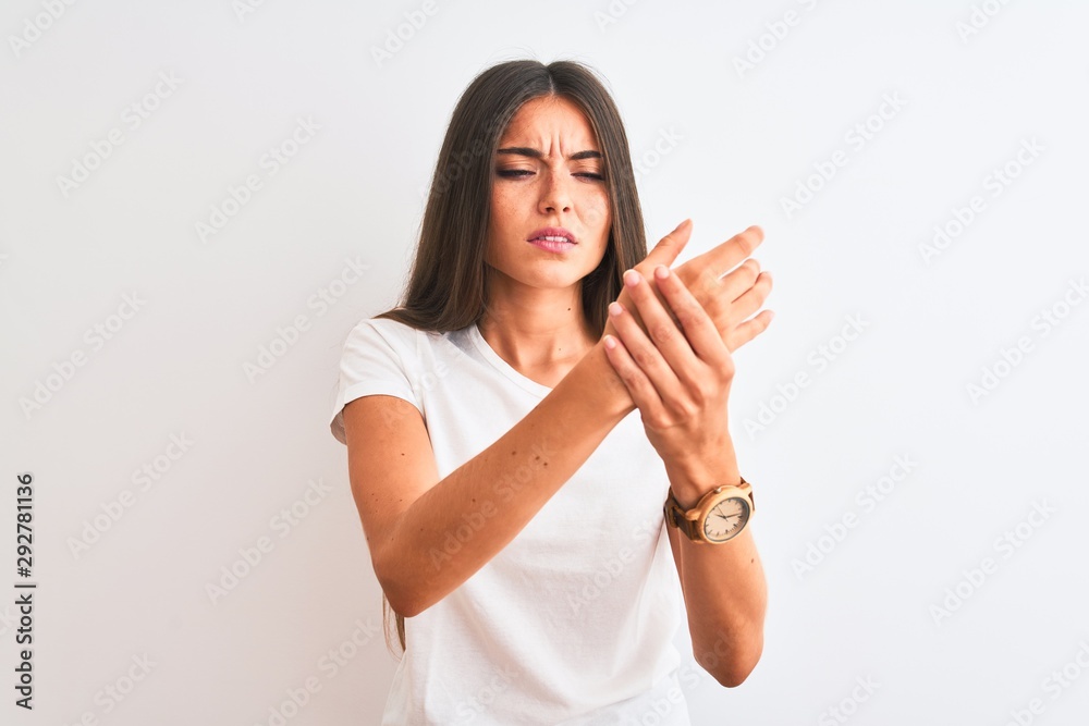 Young beautiful woman wearing casual t-shirt standing over isolated white background Suffering pain on hands and fingers, arthritis inflammation Young beautiful woman wearing casual t-shirt standing over isolated white background Suffering pain on hands and fingers, arthritis inflammation