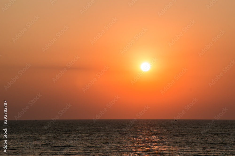 Dawn on the beach, orange-red gradient in the sky, sun, golden hour. Sunrise, sunset. Copy space.