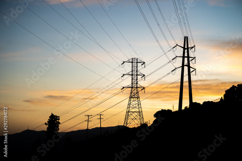 Transmission electrical lines silhouetted against sunset in Los Angeles, CA