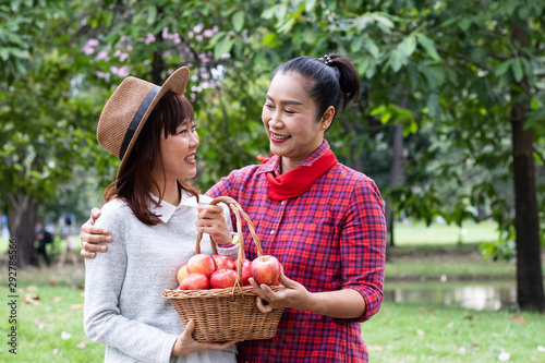 mother and daughter with apples on hand in garden - Photo