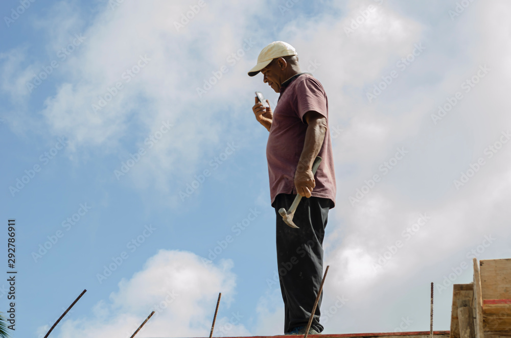 Tradesman With Hammer Against Sky Background