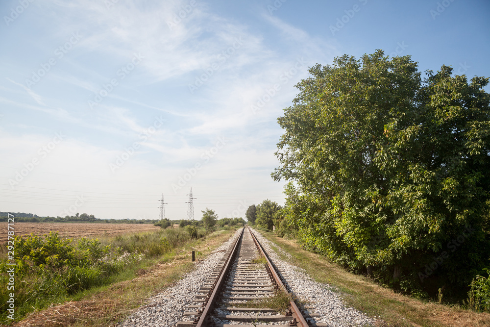 Abandoned railway track, on a defunct line in Serbia, Europe, rusty, surrounded by trees and a rural envirnoment, during a sunny afternoon Abandoned railway track, on a defunct line in Serbia, Europe, rusty, surrounded by trees and a rural envirnoment, during a sunny afternoon