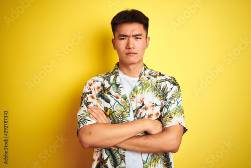 Wallpaper Mural Asian chinese man on holiday wearing summer shirt over isolated yellow background skeptic and nervous, disapproving expression on face with crossed arms. Negative person. Torontodigital.ca