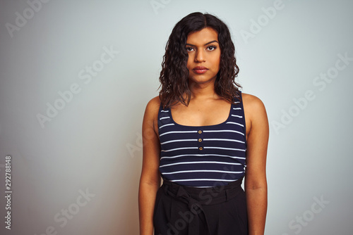 Transsexual transgender woman wearing striped t-shirt over isolated white background Relaxed with serious expression on face. Simple and natural looking at the camera.