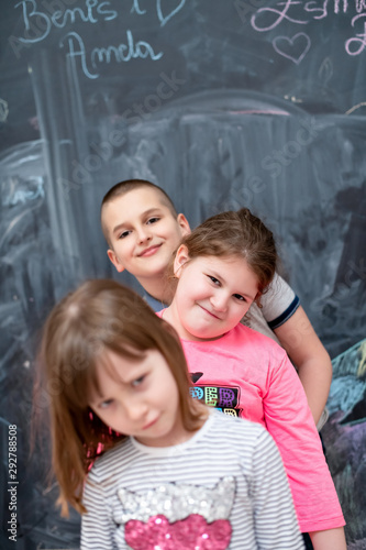 group of kids standing in front of chalkboard