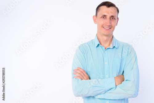 Studio shot of happy businessman smiling with arms crossed