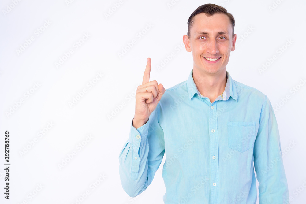 Studio shot of happy businessman pointing finger up Studio shot of happy businessman pointing finger up