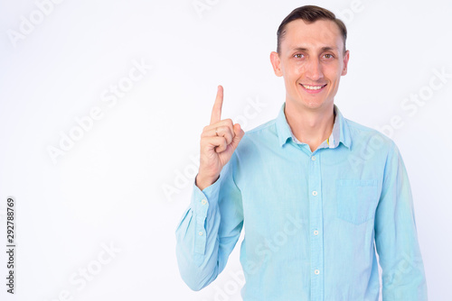 Studio shot of happy businessman pointing finger up © Ranta Images