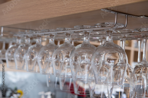 Wine glasses stacked hanging above bar