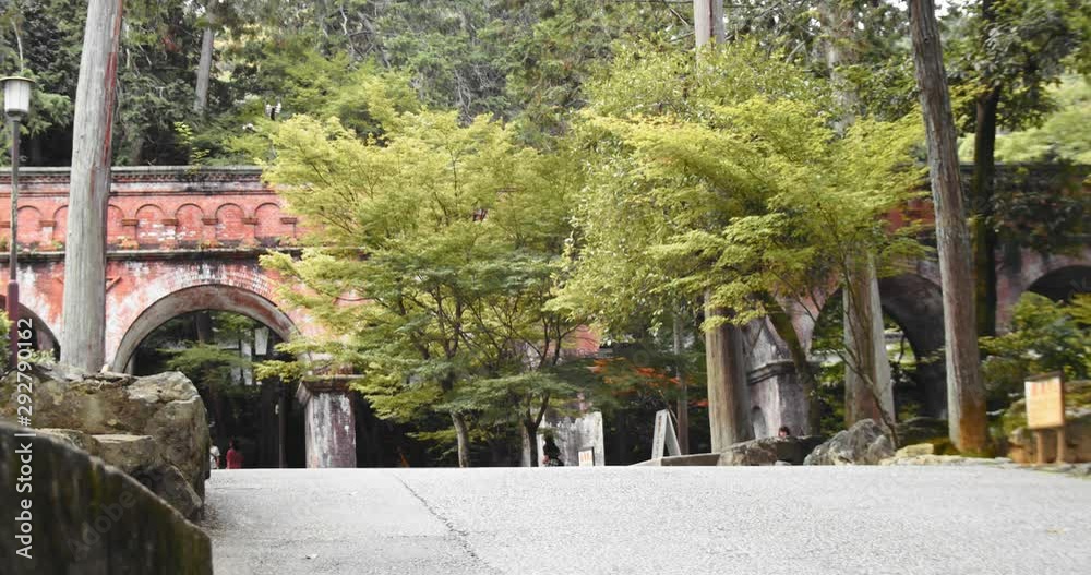 Slide shot of brick bridge behind the trees in Kyoto, Japan 4K slow motion Slide shot of brick bridge behind the trees in Kyoto, Japan 4K slow motion