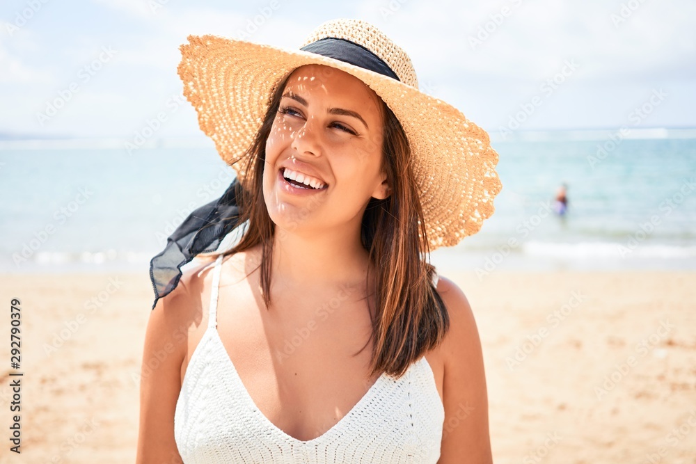 Young beautiful woman smiling happy enjoying summer vacation at the beach