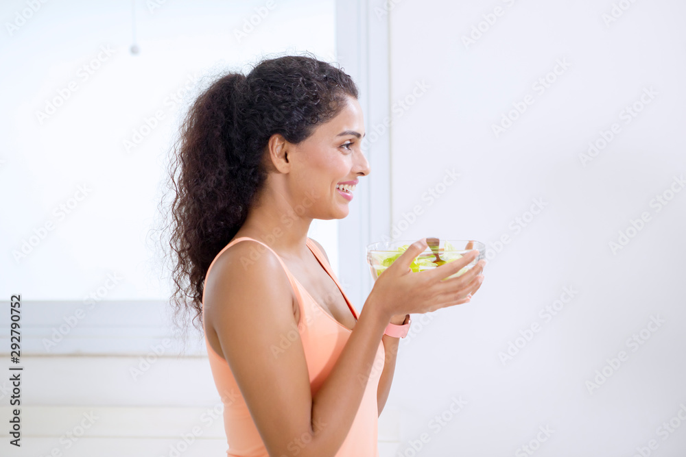 Smiling woman holding a bowl of vegetable salad Smiling woman holding a bowl of vegetable salad