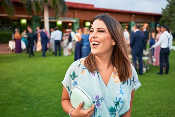 Young beautiful and elegant woman with wedding guest dress smiling happy and cheerful