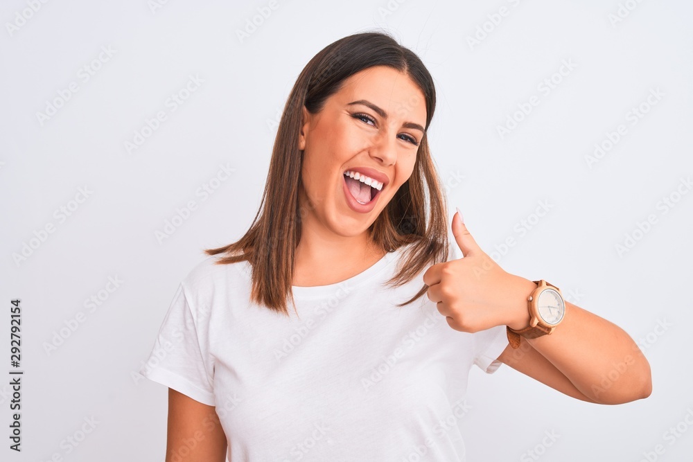 Portrait of beautiful and young brunette woman standing over isolated white background doing happy thumbs up gesture with hand. Approving expression looking at the camera showing success. Portrait of beautiful and young brunette woman standing over isolated white background doing happy thumbs up gesture with hand. Approving expression looking at the camera showing success.