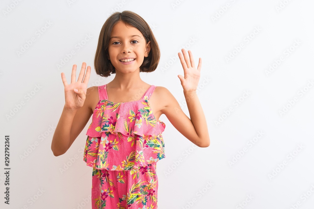 Young beautiful child girl wearing pink floral dress standing over isolated white background showing and pointing up with fingers number nine while smiling confident and happy. Young beautiful child girl wearing pink floral dress standing over isolated white background showing and pointing up with fingers number nine while smiling confident and happy.