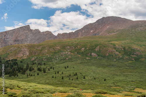 Alpine landscape of green meadow, mountain tops, and clouds at the top of Guanella Pass in Colorado © Angela