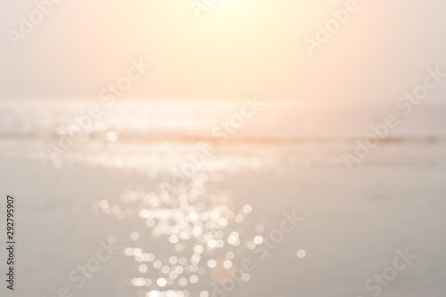 blur sand beach with bokeh sun light abstract background.Summer holiday concept: Abstract bokeh light and blurry beach sunrise background