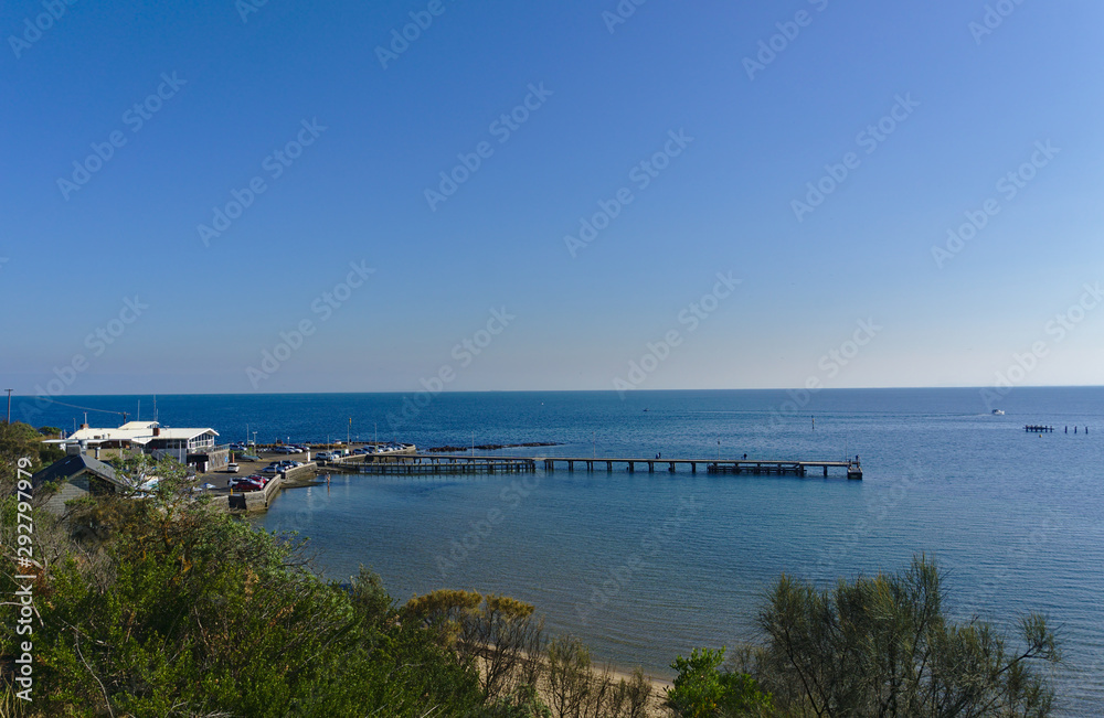 Beach pier with calm sea during sunny day with blue sky Beach pier with calm sea during sunny day with blue sky