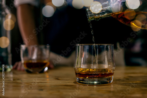 Fototapeta Naklejka Na Ścianę i Meble -  glass of whiskey and ice on wooden table