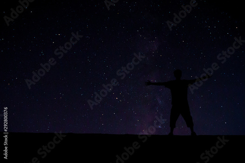 Successful man at the peak. Among the beautiful stars in the night sky.