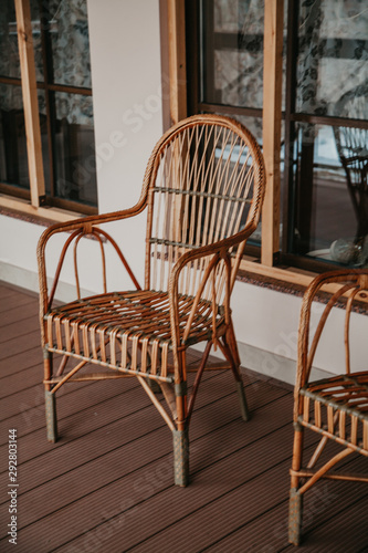 Wicker chair is on autumn porch