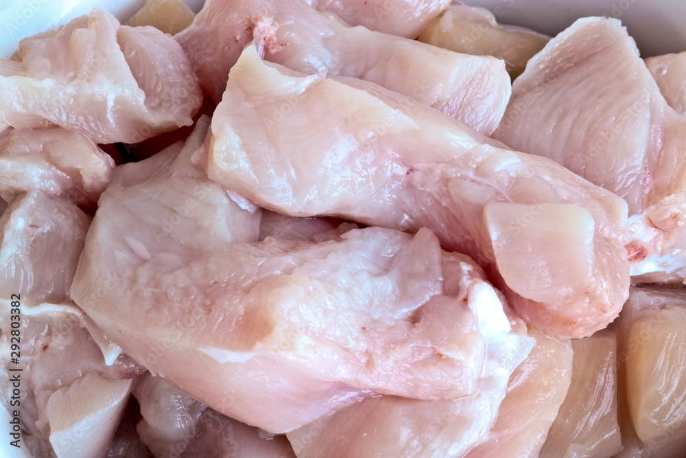 Coarsely chopped pieces of chicken fillet. Raw meat before cooking. Coarsely chopped pieces of chicken fillet. Raw meat before cooking.