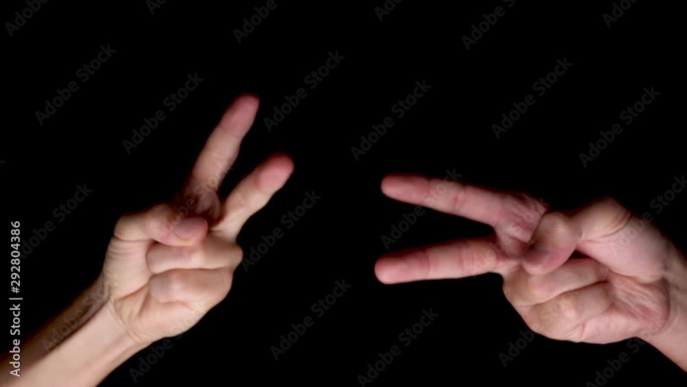 View Of Two Hands Playing Rock, Paper, Scissors Against Black Background. Locked Off View Of Two Hands Playing Rock, Paper, Scissors Against Black Background. Locked Off