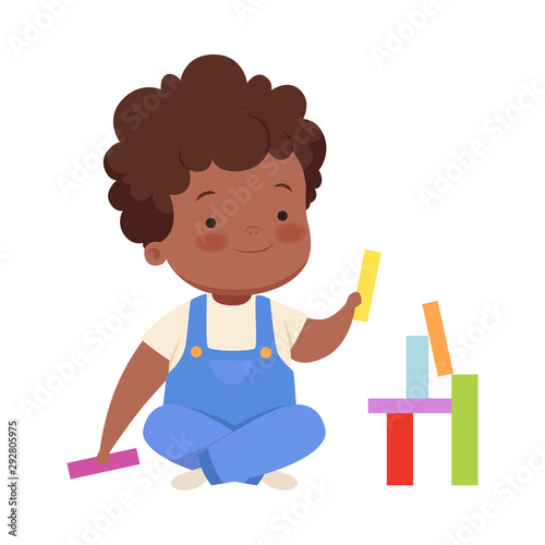 Boy is building from colorful blocks. Vector illustration on a white background.