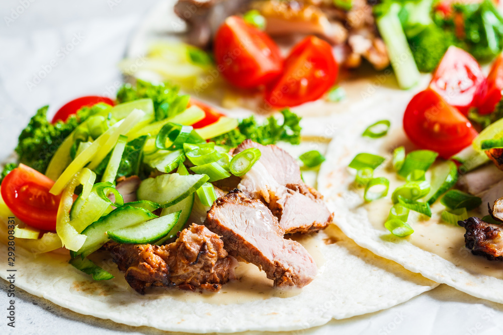 Healthy mini tortillas with grilled chicken, meat, fresh vegetables on light grey background. Healthy mini tortillas with grilled chicken, meat, fresh vegetables on light grey background.
