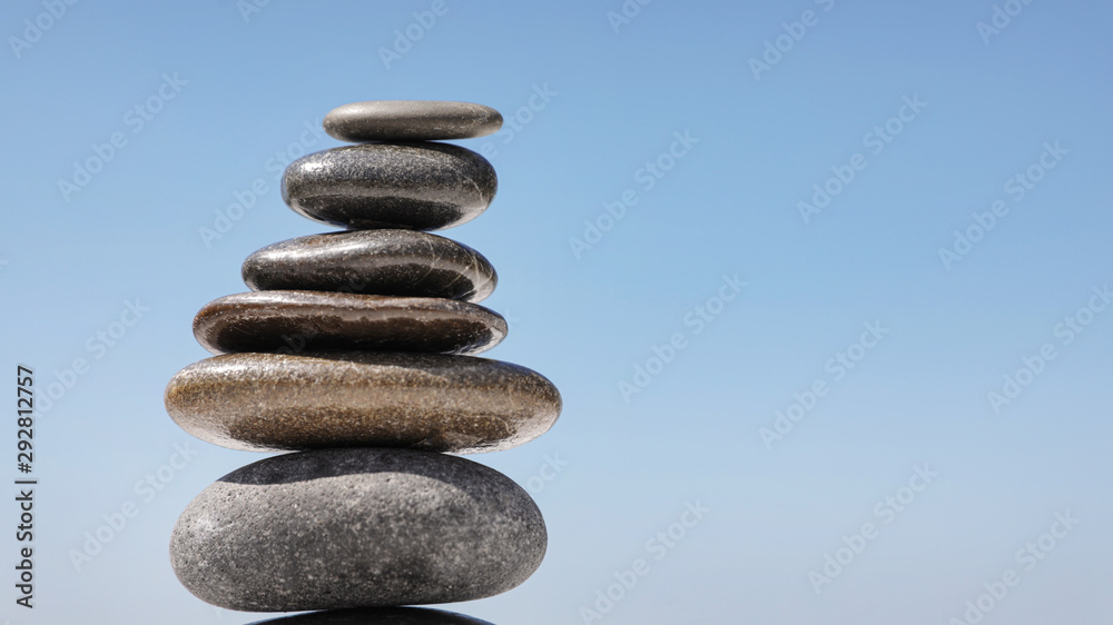Stack of stones against blue sky, space for text. Zen concept Stack of stones against blue sky, space for text. Zen concept