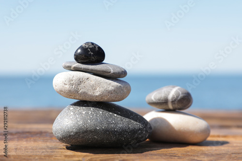 Stacks of stones on wooden pier near sea. Zen concept