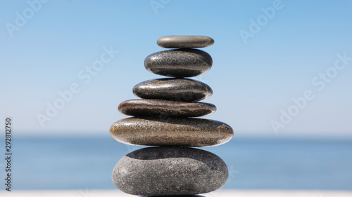 Stack of stones against blurred seascape  closeup. Zen concept