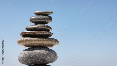 Stack of stones against blue sky, space for text. Zen concept