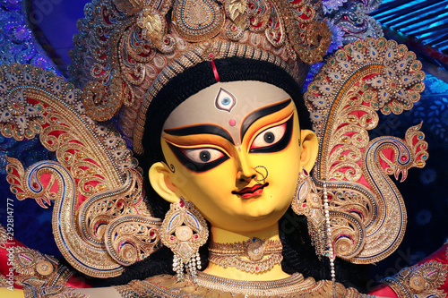 Goddess Durga idol at decorated Durga Puja pandal, shot at colored light, at Kolkata, West Bengal, India. Durga Puja is biggest religious festival of Hinduism and is now celebrated worldwide.