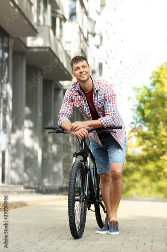 Fototapeta Naklejka Na Ścianę i Meble -  Handsome man with modern bicycle on city street