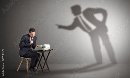 Little man working and a big shadow arguing with him © ra2 studio