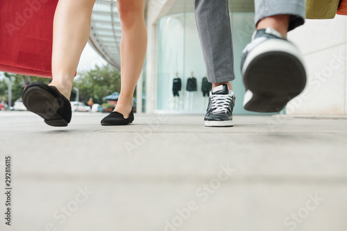 Feet of people walking in the street after shopping together in mall, selective focus © DragonImages